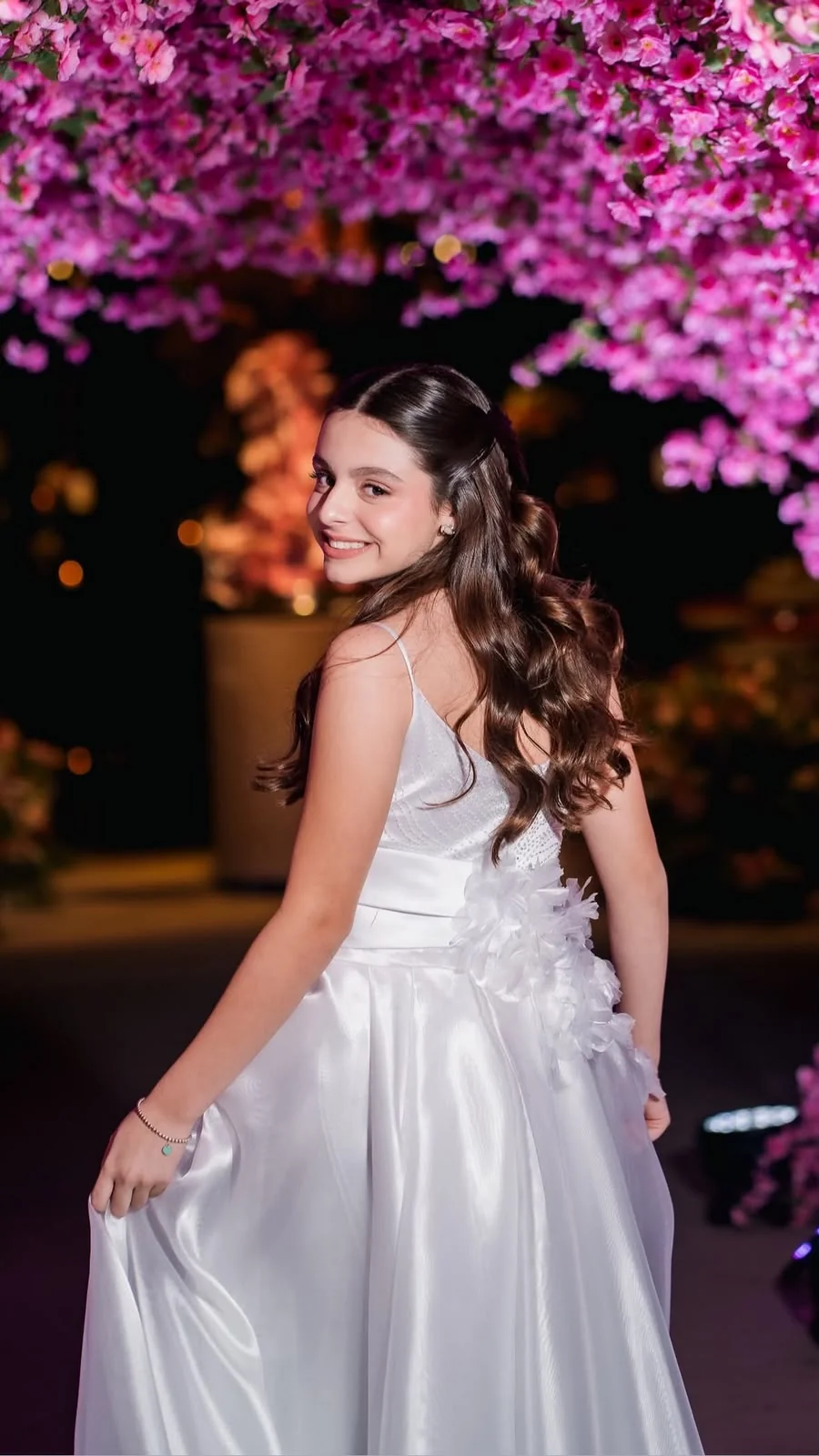 Debutante em festa com penteado de ondas longas e maquiagem delicada