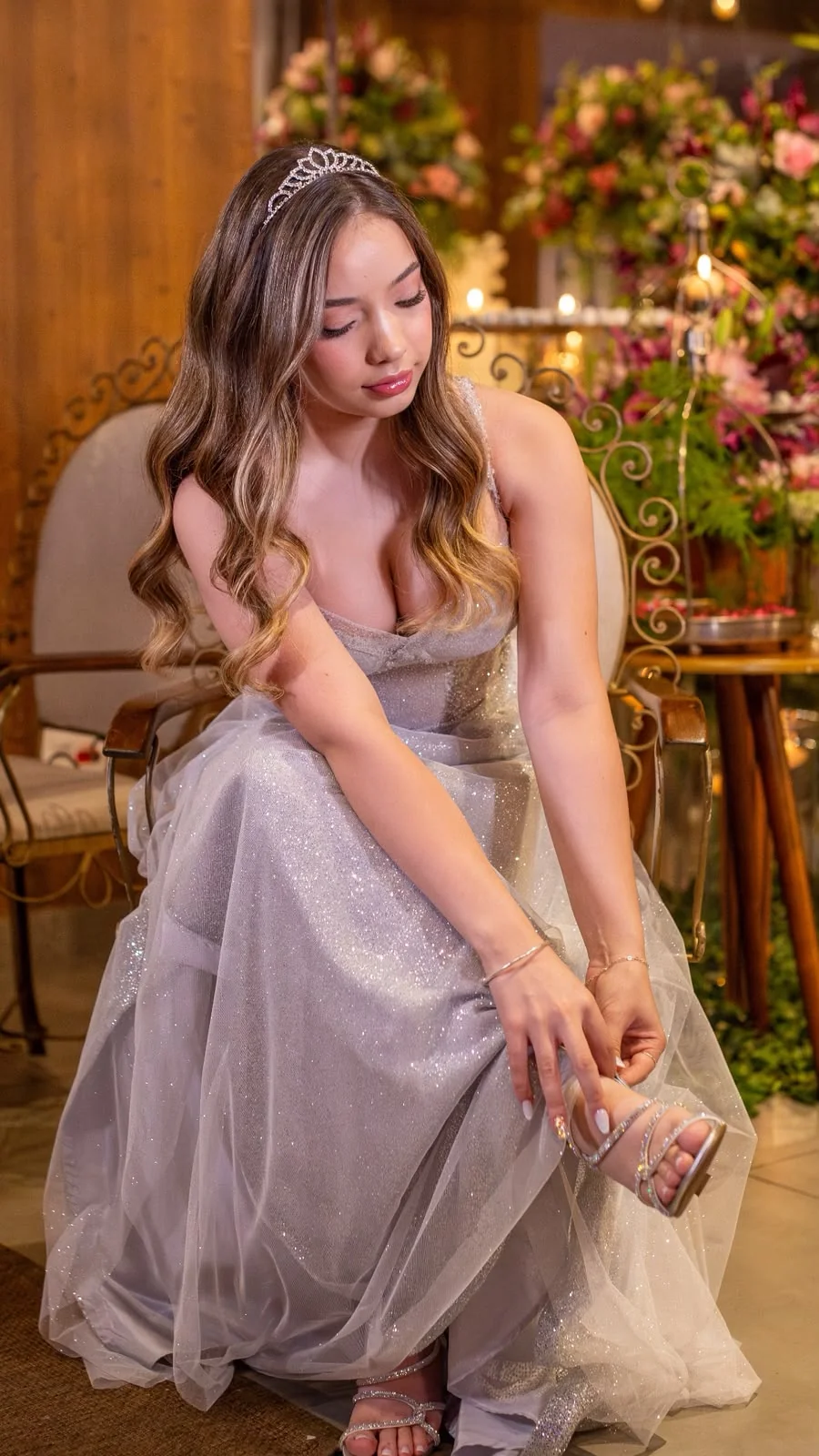 Debutante de vestido prata com cabelos ondulados e maquiagem suave