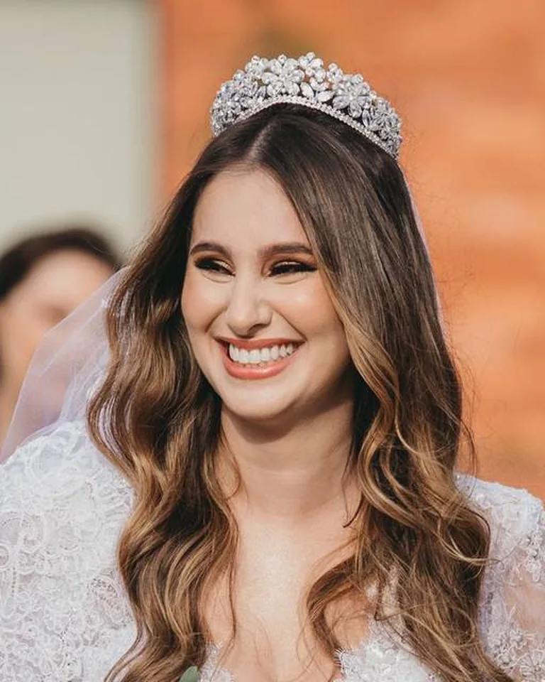 Noiva sorridente com tiara, cabelo solto e maquiagem luminosa