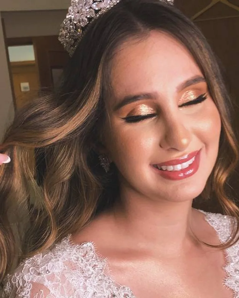 Noiva com cabelo ondulado e maquiagem em tons rosados